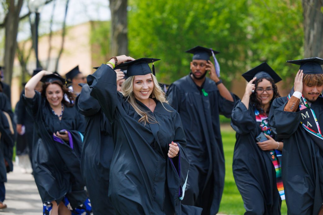 Female graduate smiling holding her mortarboard