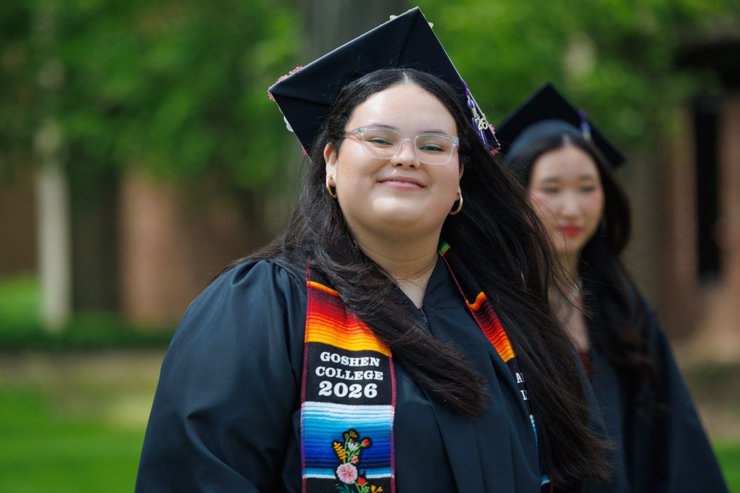 Smiling Latina graduate wearing a stole representing her heritage during commencement
