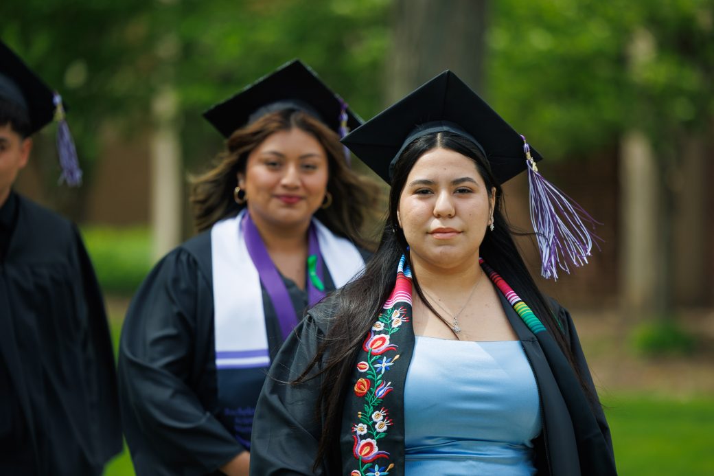 Female graduate walking in processional with decorative stole