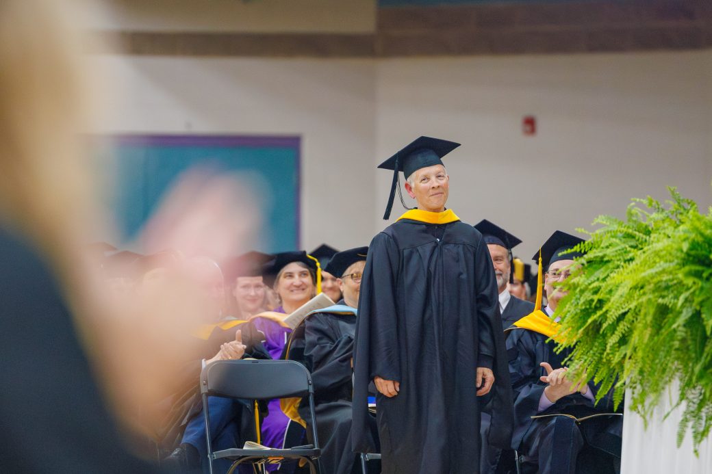 Female professor standing up in recognition of retirement