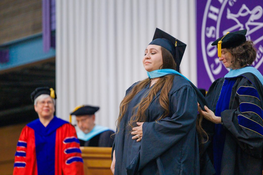 Female graduate receiving stole over head