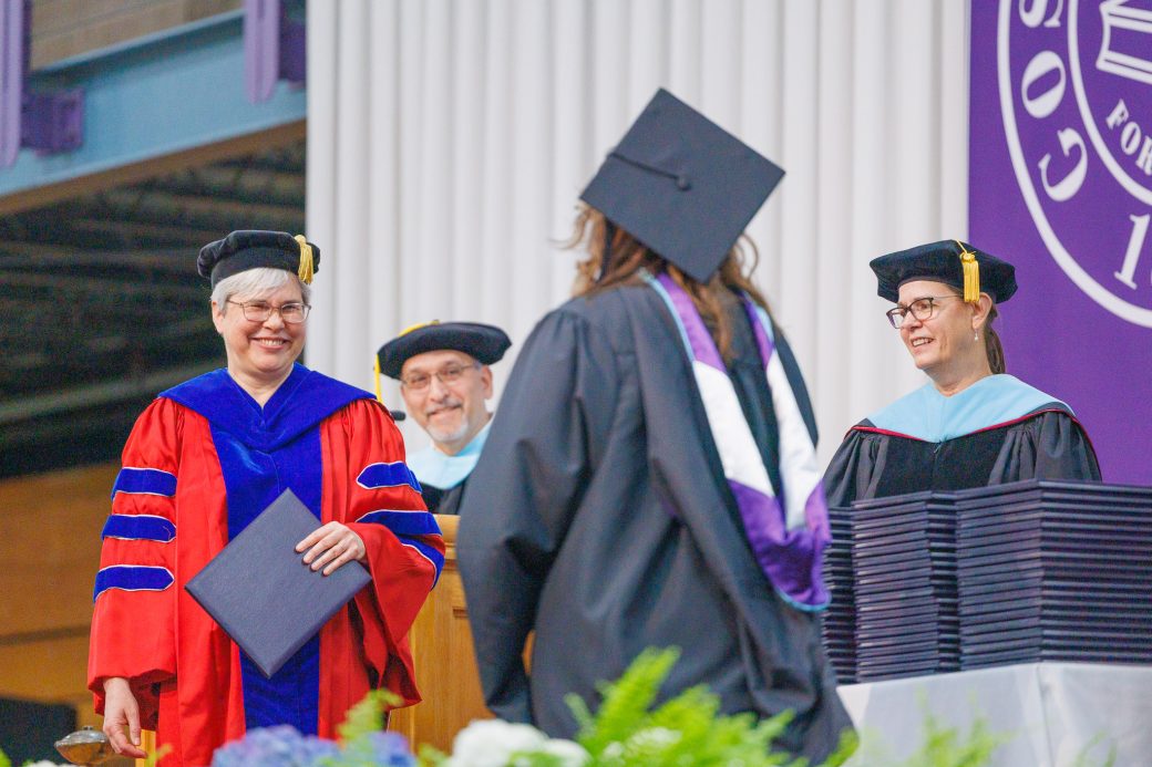 Graduate walking toward President Rebecca to get diploma