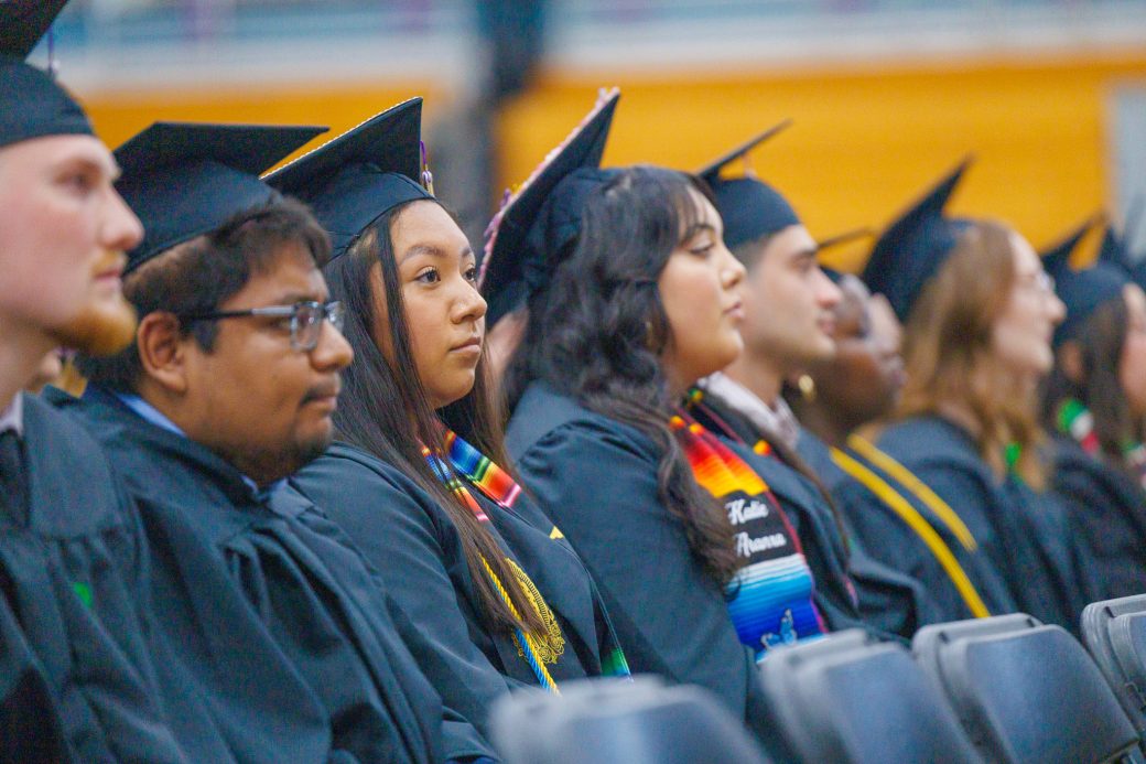 Group of graduates sitting together waiting for diploma