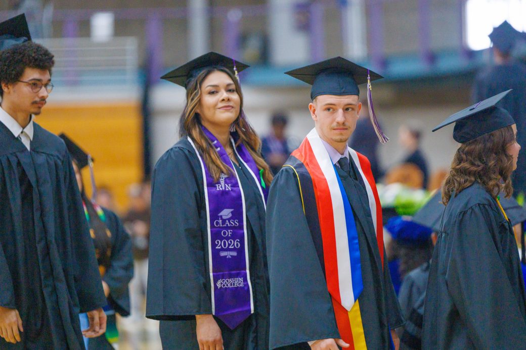 Female and male graduates looking on to their families