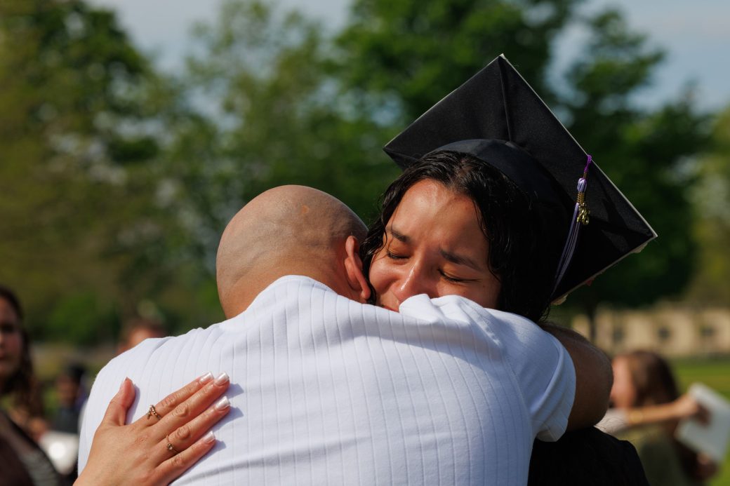 Emotional graduate hugging father