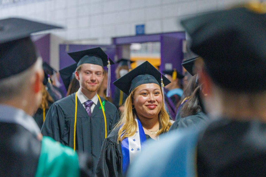 Students exiting commencement while faculty and staff clap along processional route