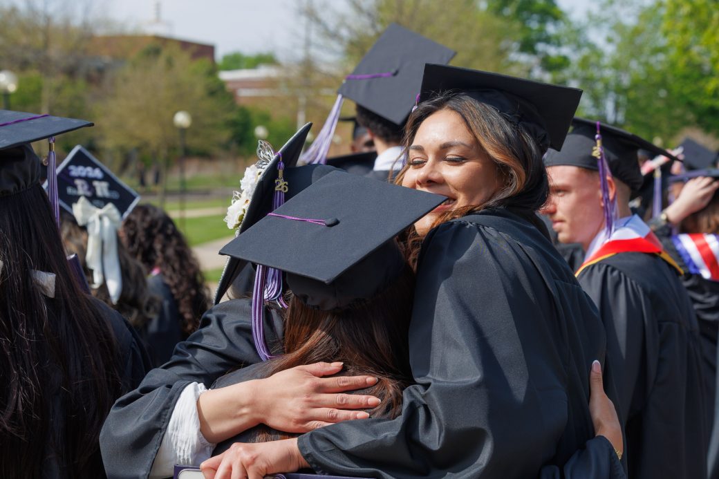 Three graduate students hugging