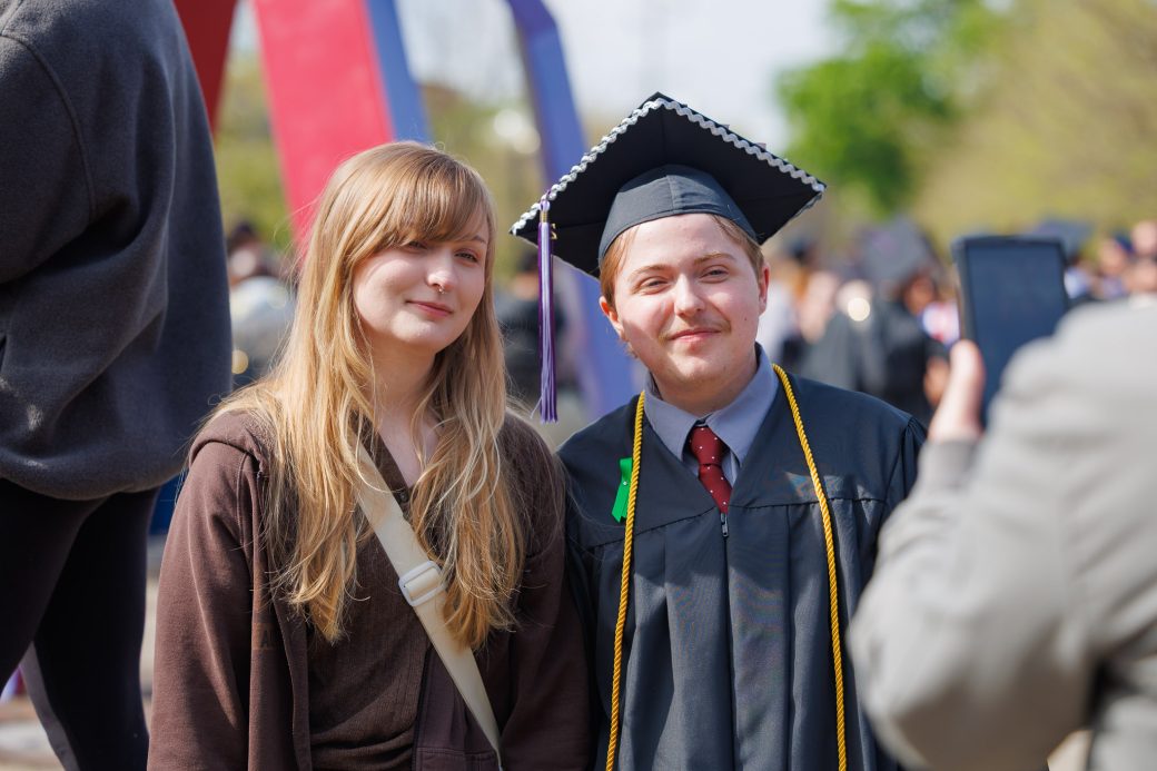 graduate with friend posed beside them