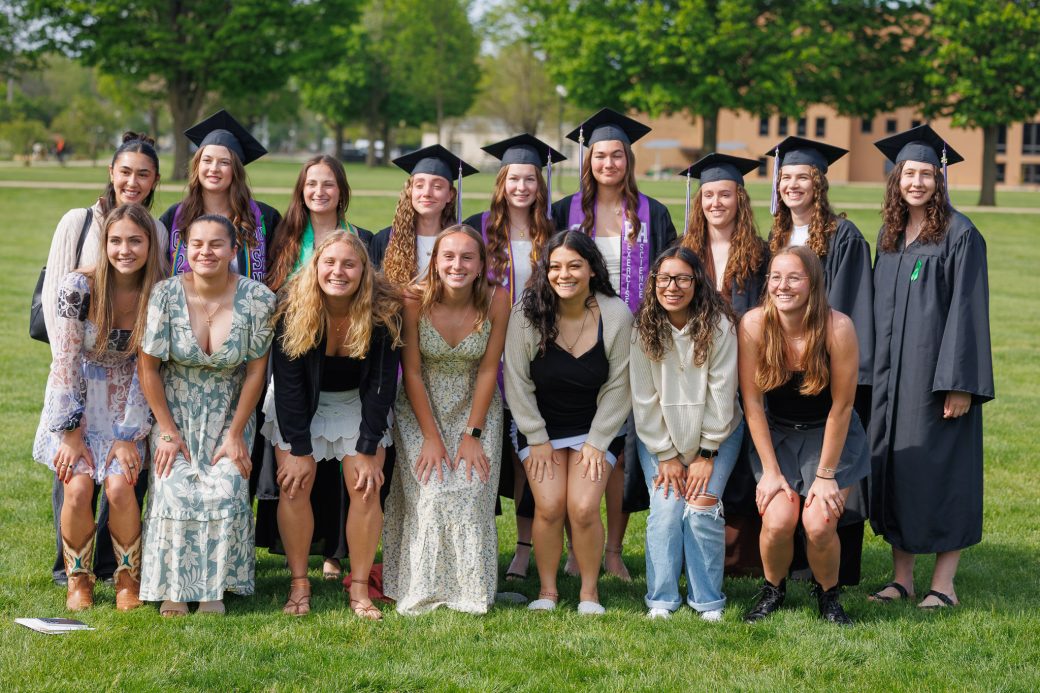 Female sports team with graduates in a group photo