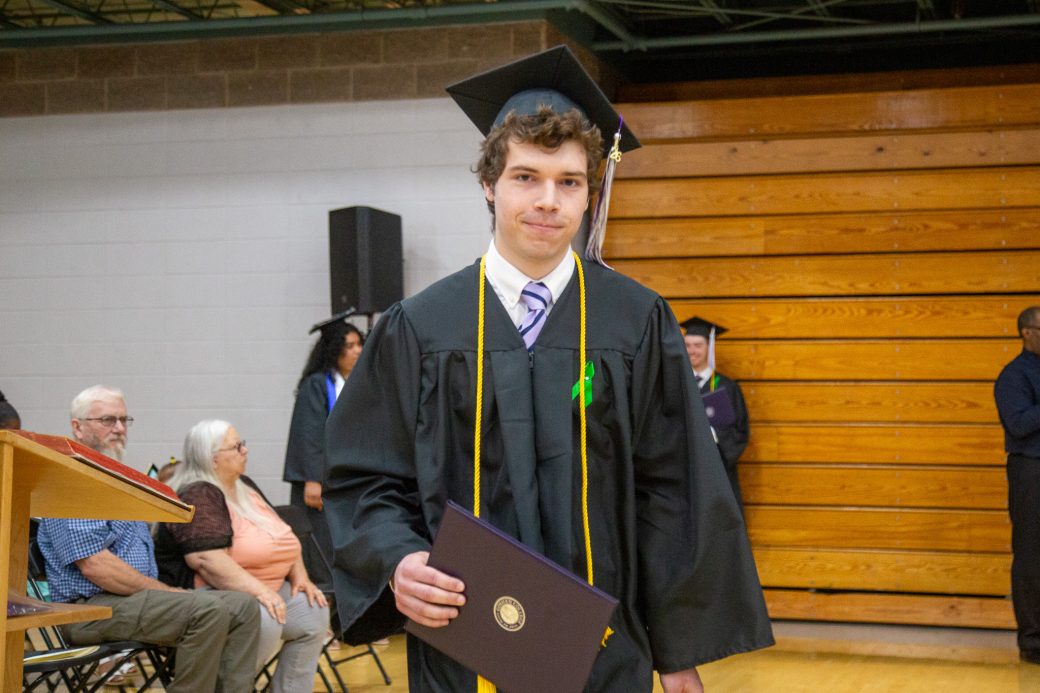 Graduate holding camera walking after receiving it