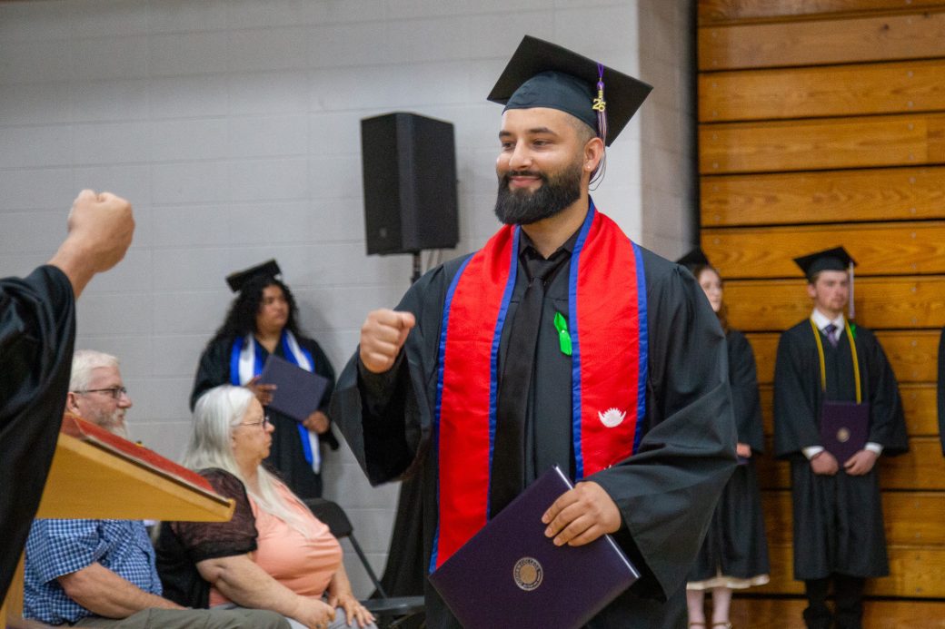 Graduate fist b*umping after receiving diploma