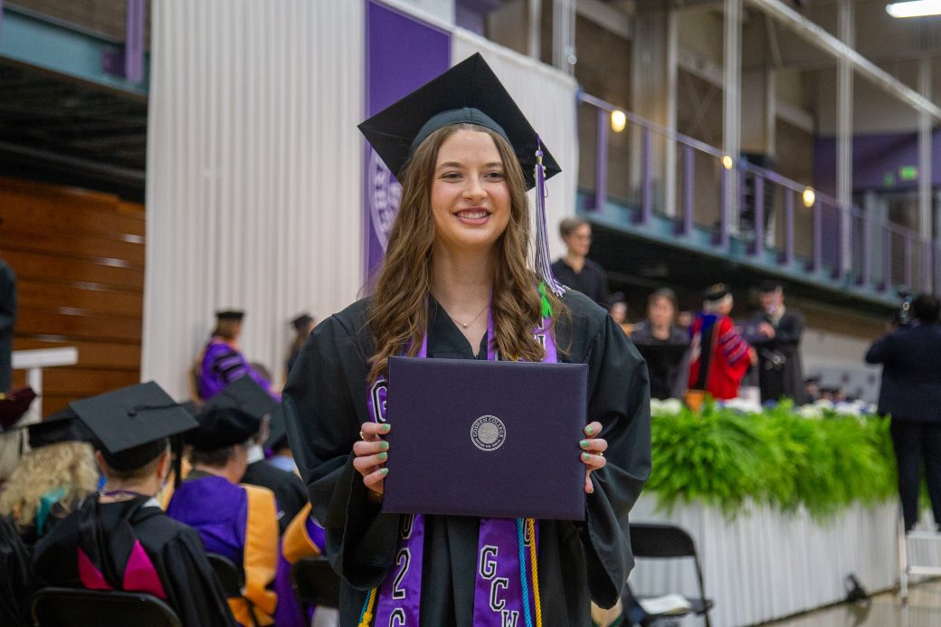 Graduate holding diploma after walking across the stage