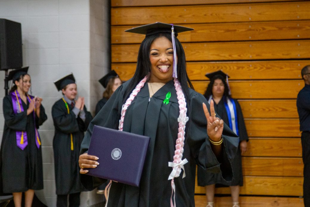 Graduate with diploma giving peace sign