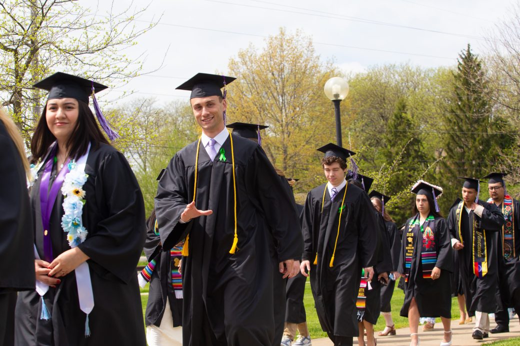 male graduate waving for photo