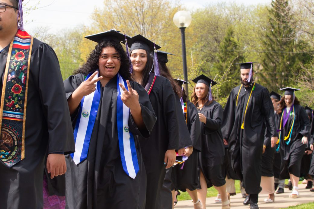 graduate giving peace signs
