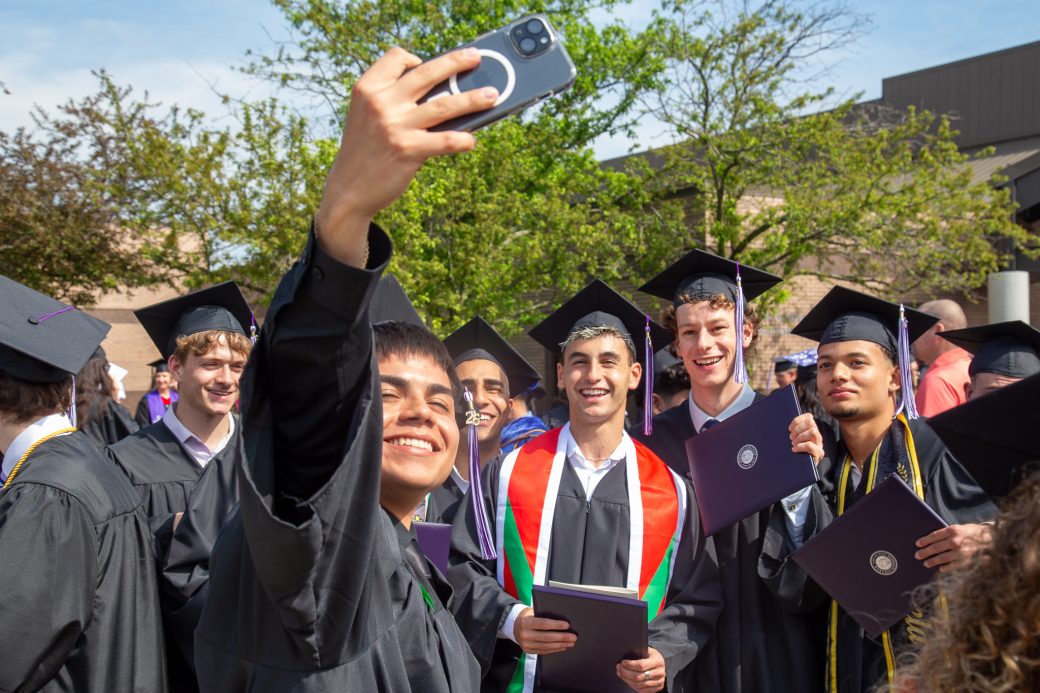 Graduate taking selfie with graduate friends