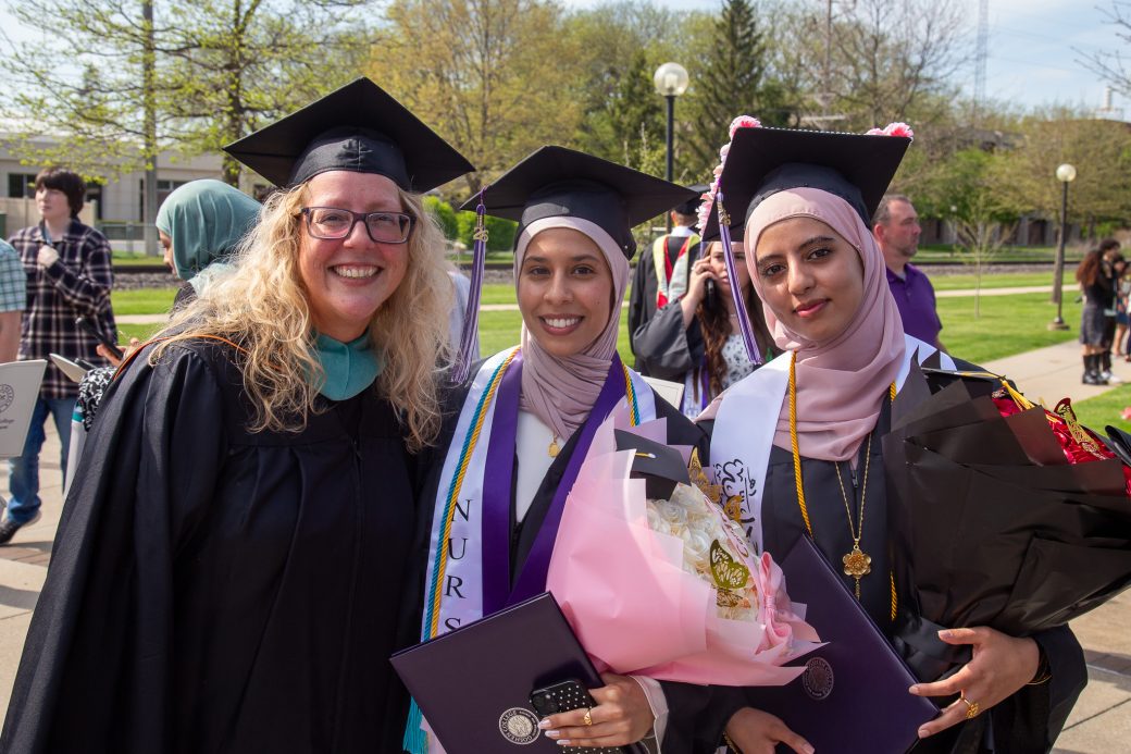 Group of three graduates posed together