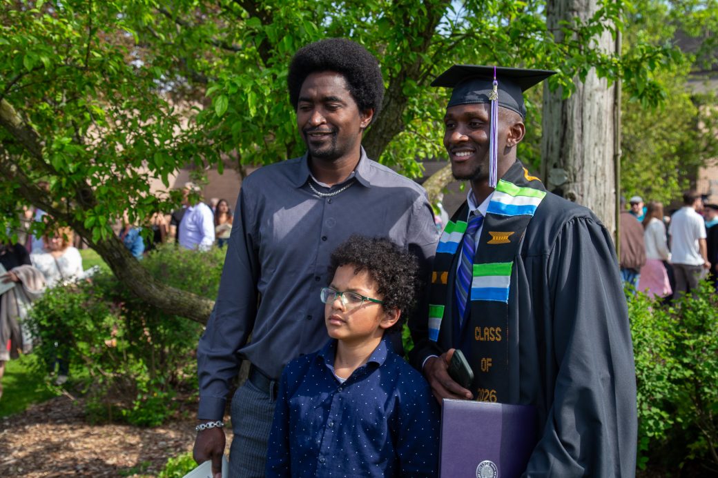 Graduate surrounded by family and friends in outdoor celebration