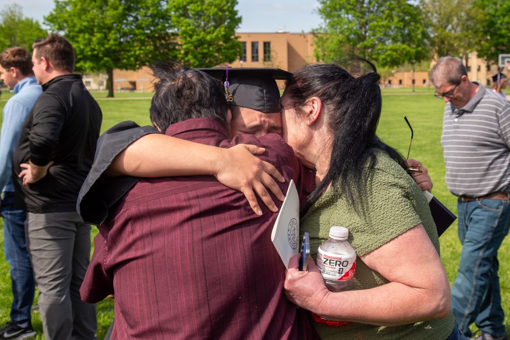 Graduate sharing emotional hugs with friends after graduation