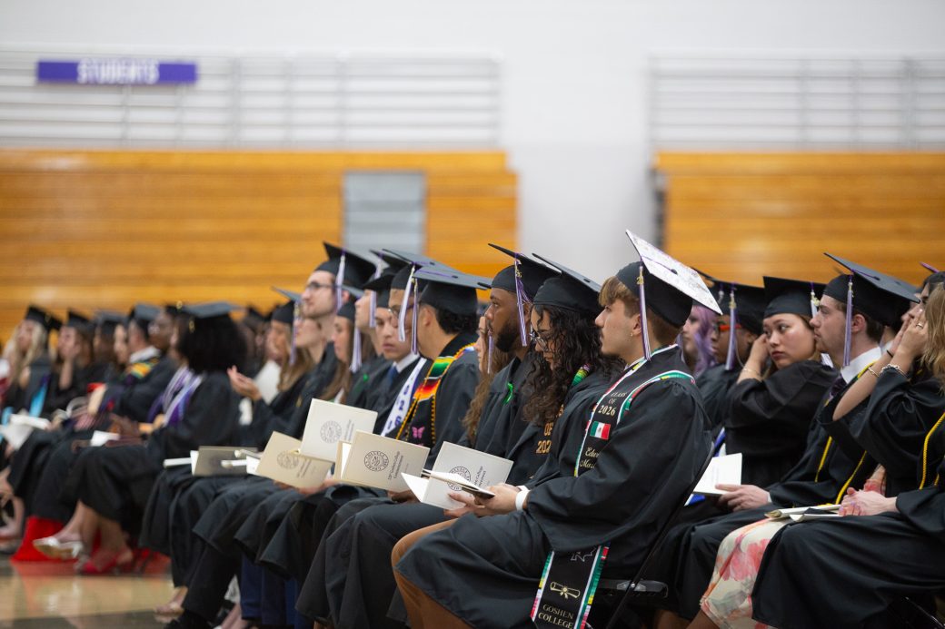 Group of graduates seated together looking toward speaker