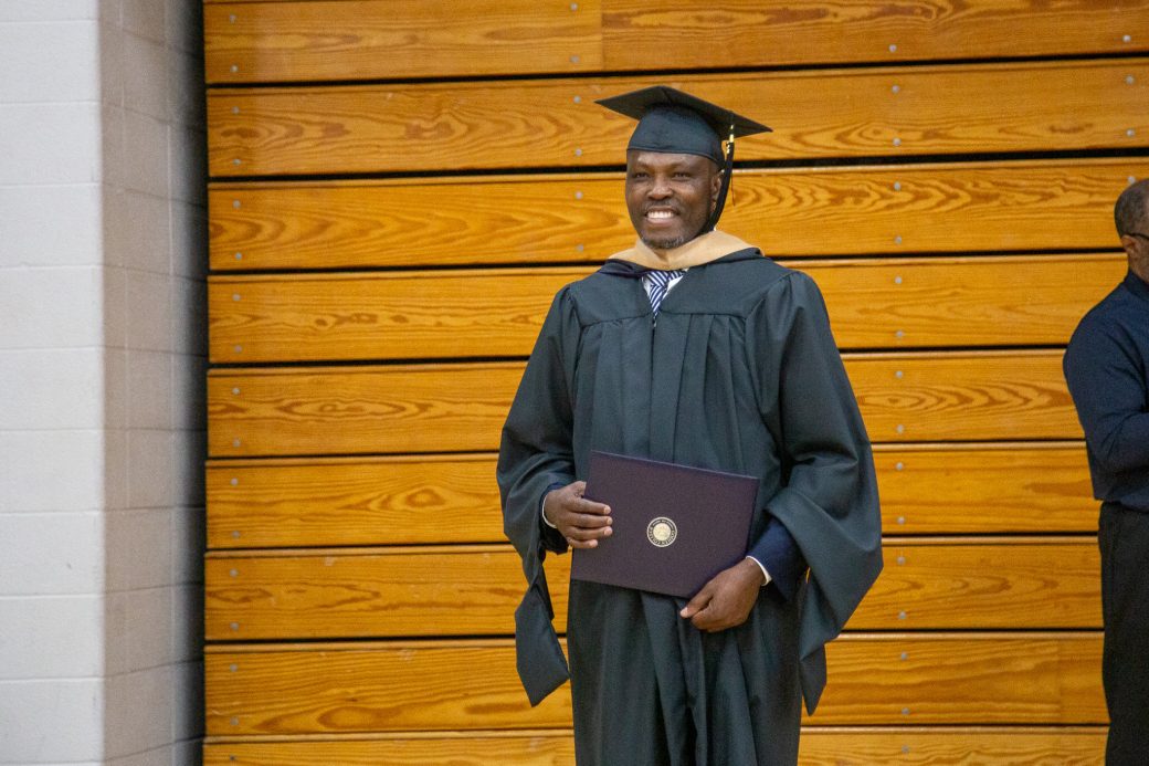 Graduate posing with diploma after commencement