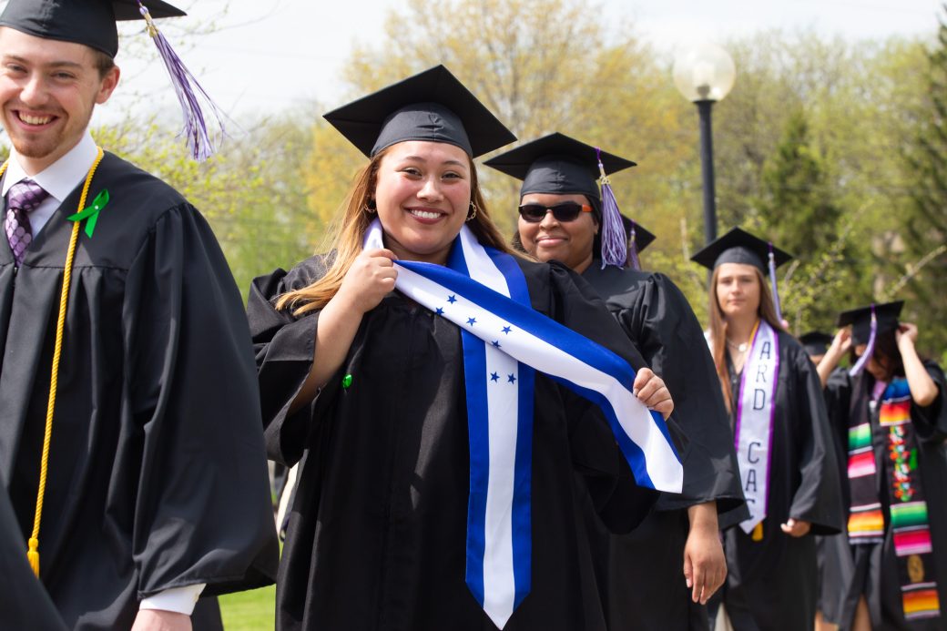 Female hispanic graduate showing off stole