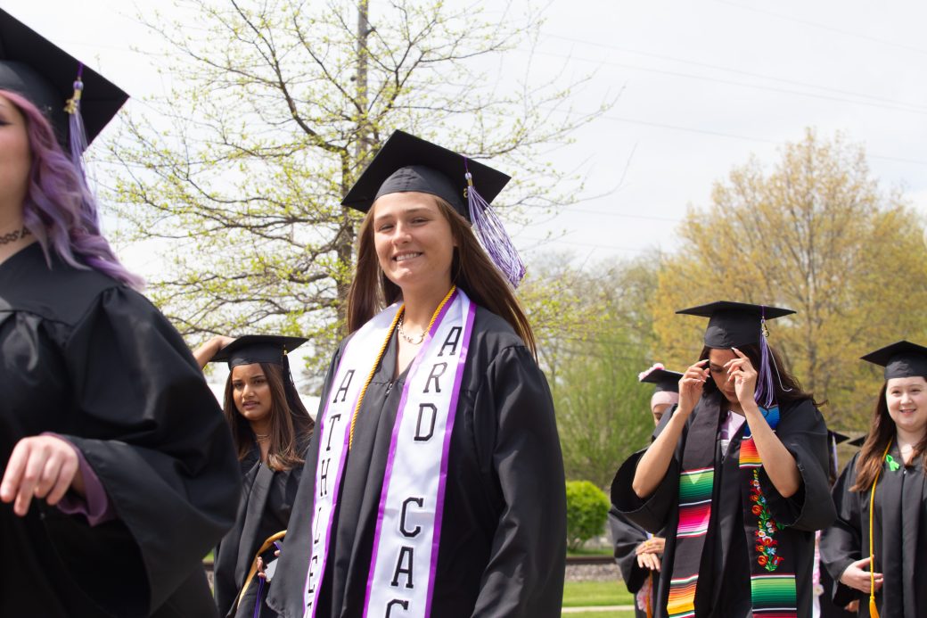 Graduate smiling while heading into Roman Gingerich Recreation-Fitness Center