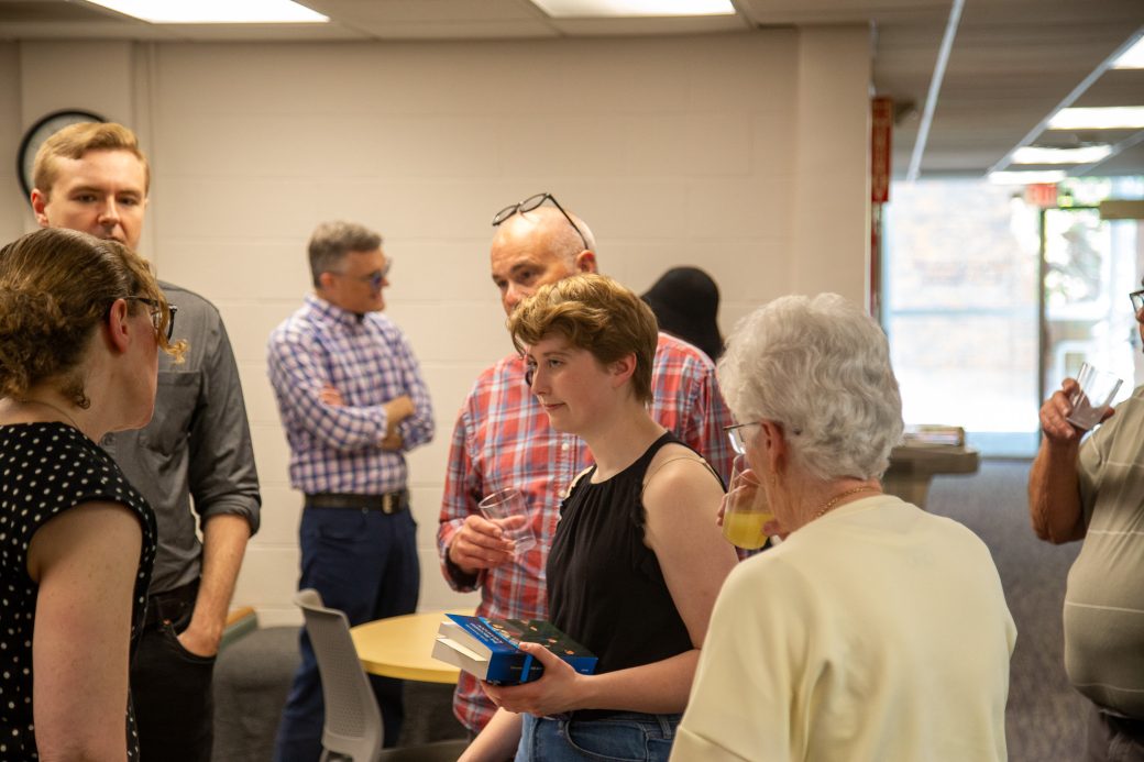 Graduates and families gathering at a Goshen College department reception during commencement weekend