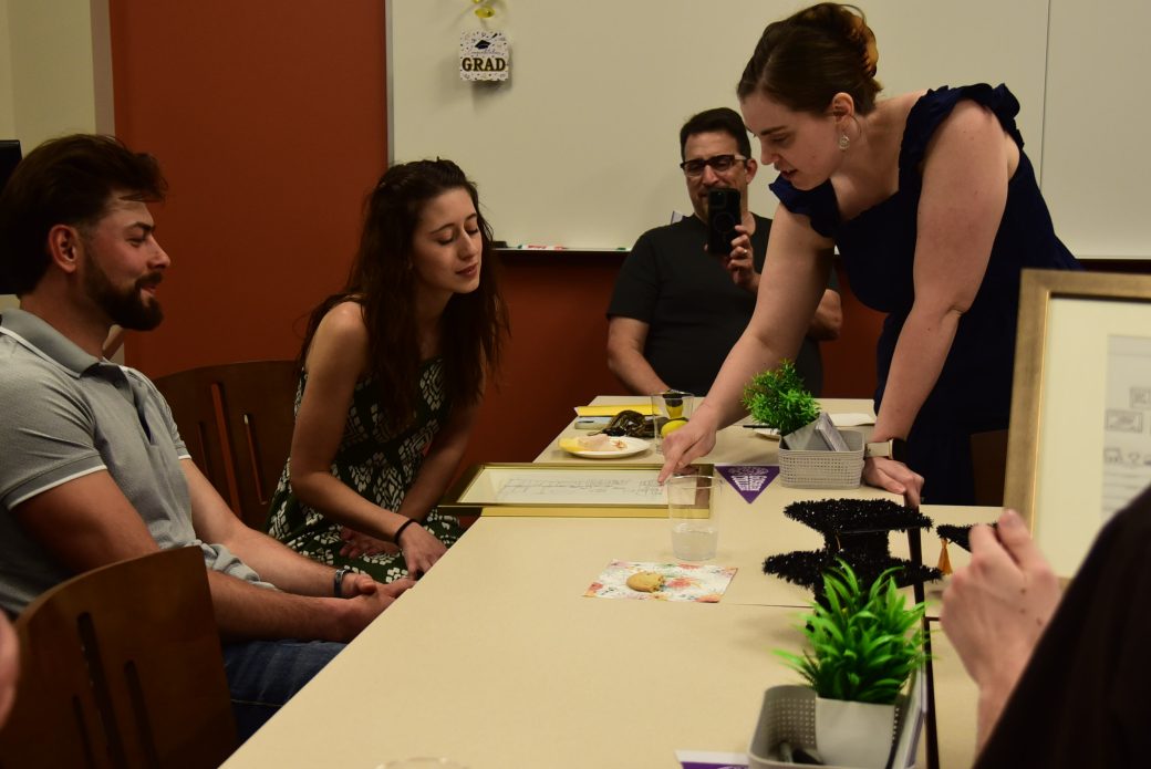 Group sitting at a table looking at framed image