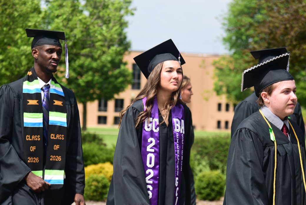 Female graduate walking wearing GC 2026 stole
