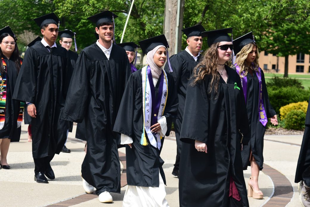 Female graduate walking with group into Roman Gingerich Recreation-Fitness Center