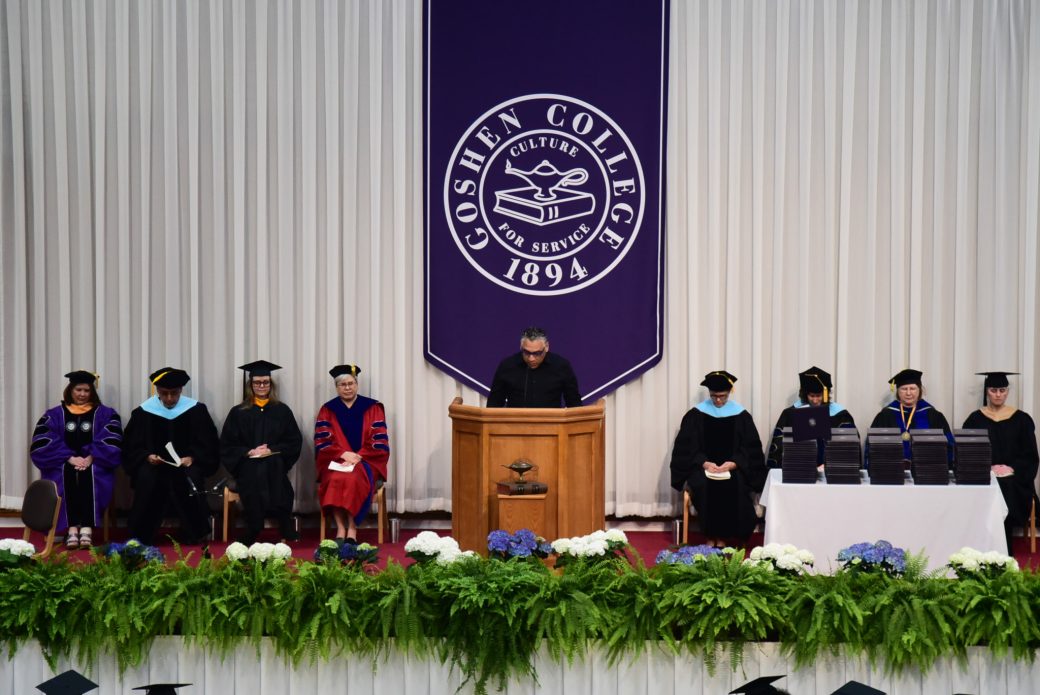 Faculty and guest speakers seated on stage awaiting their turn to speak