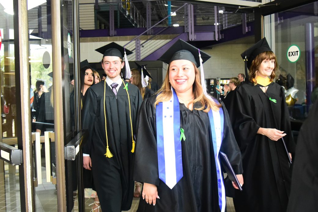 Graduates walking through entrance toward outside after commencement