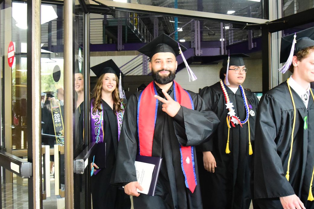 Graduates stepping through doorway on their way outside
