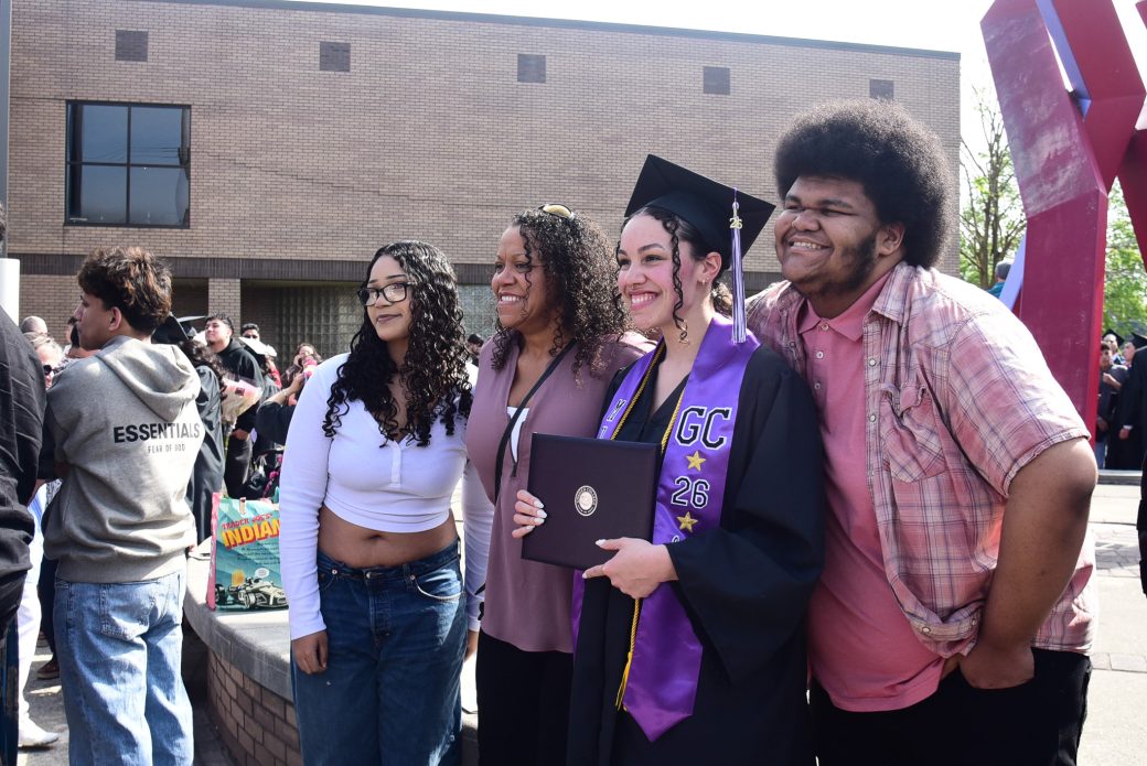 Graduate posed with family and friends outside