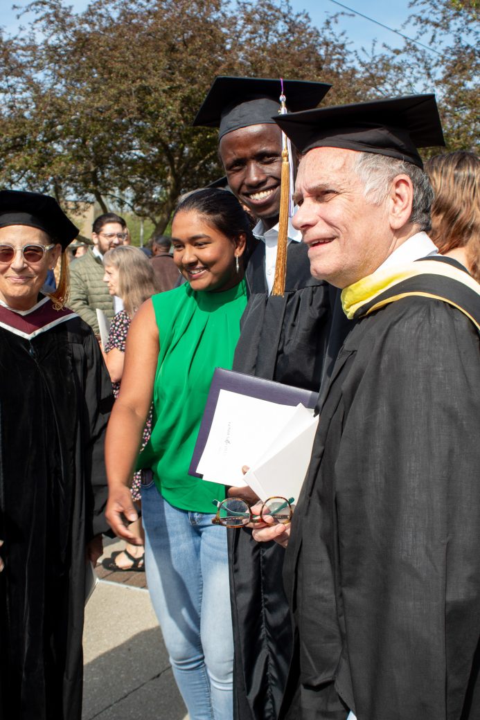 Graduate with family and faculty smiling