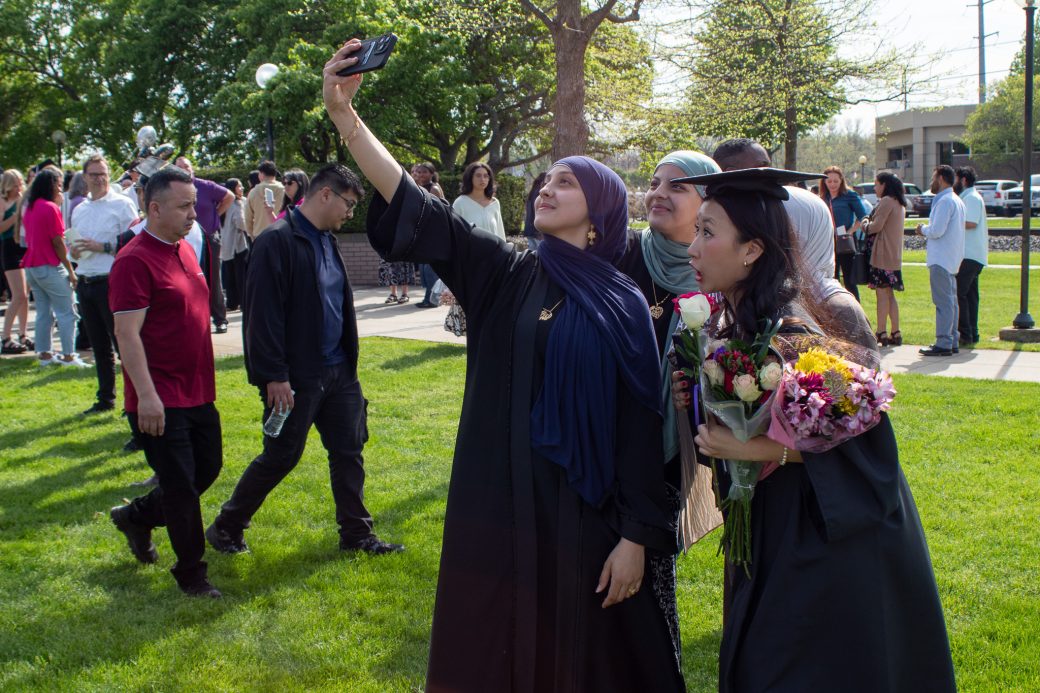 Graduate taking selfie with friends