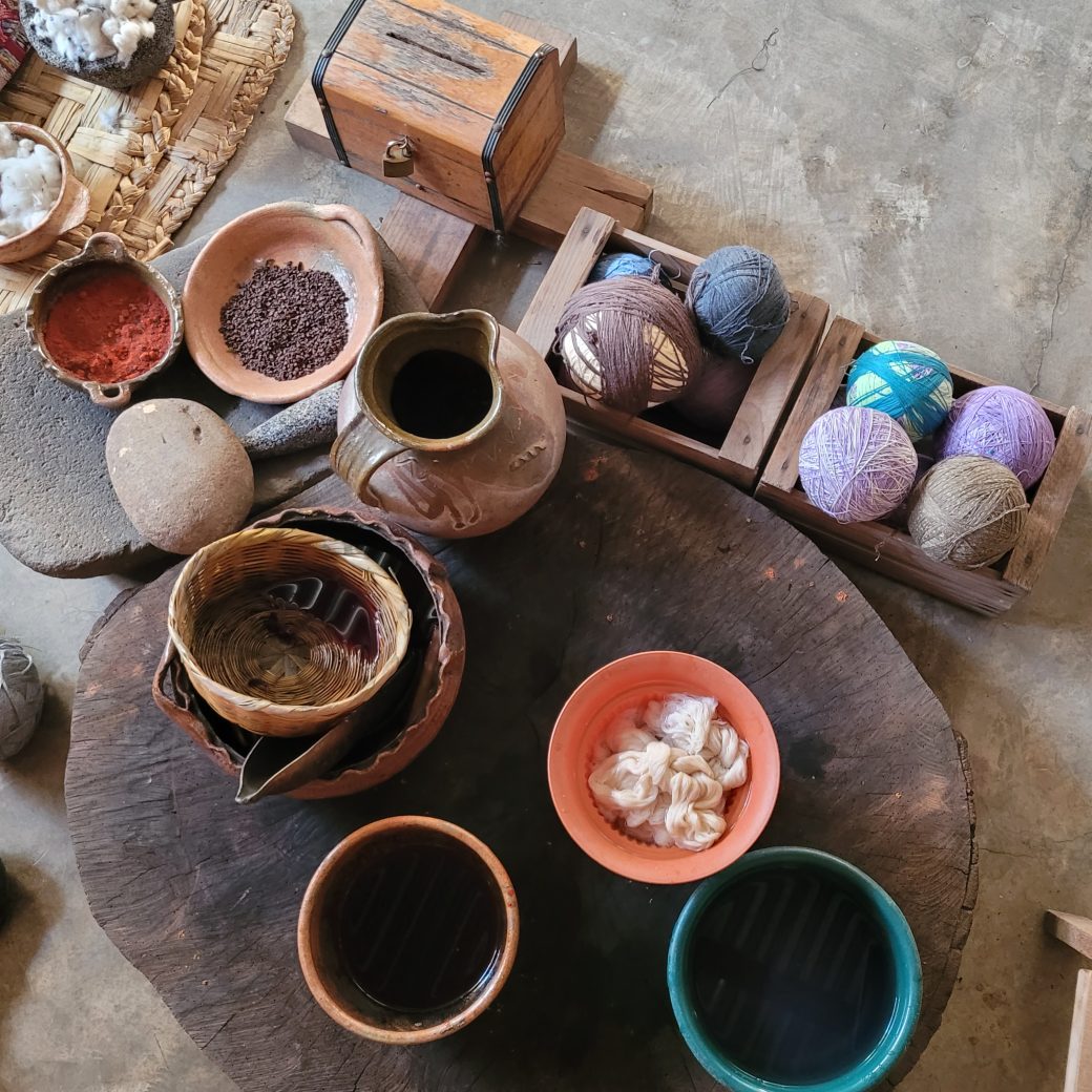 Pots and baskets neatly organized on the ground and filled with different natural items.
