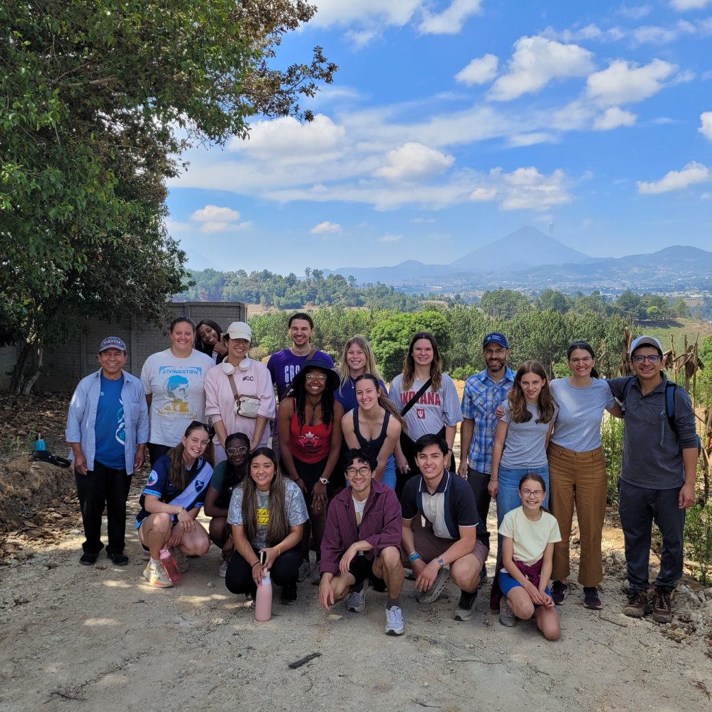 A group of people posing at the top of the mountain.