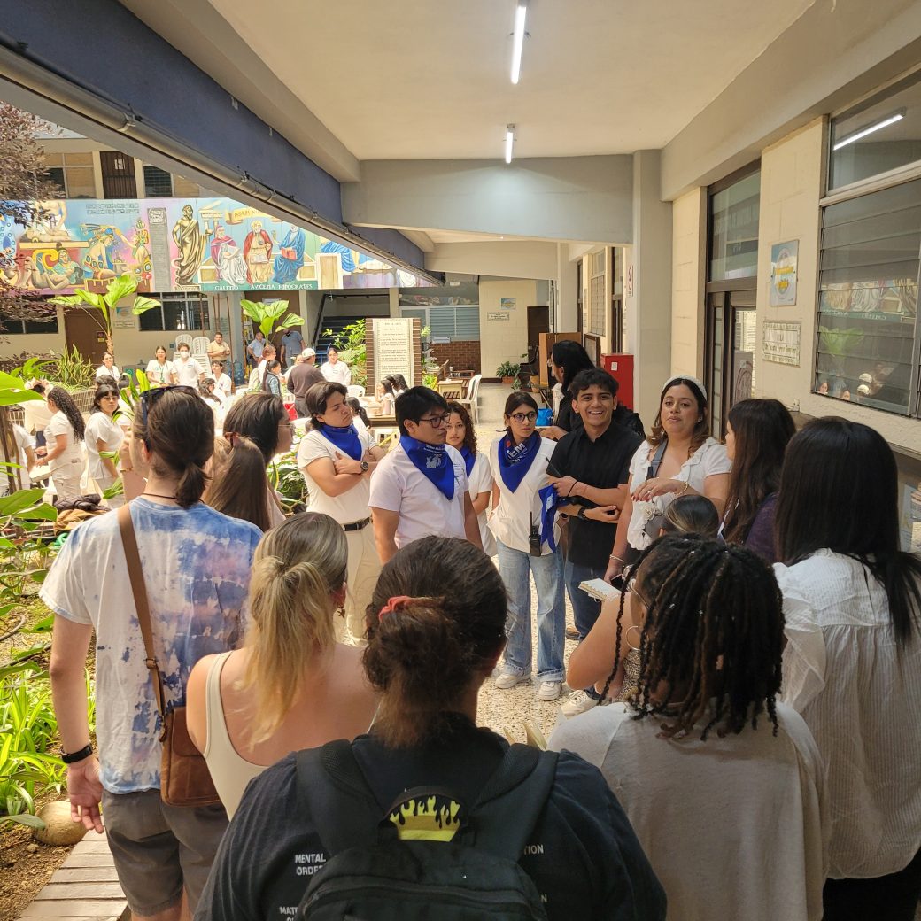 A group of people standing in a circle in a hallway.