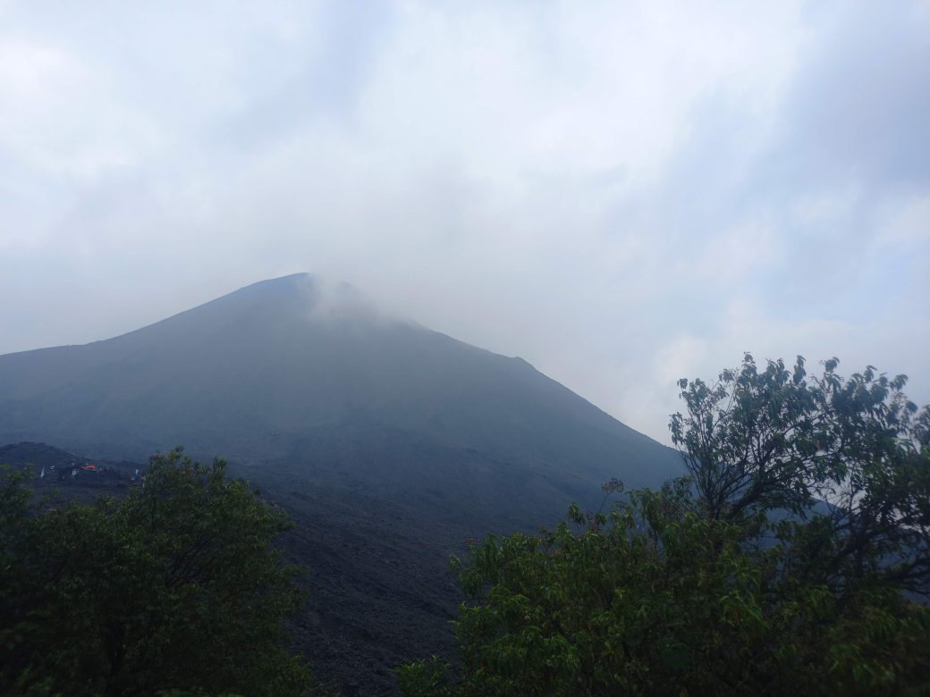 A mountain peak covered with wispy clouse.