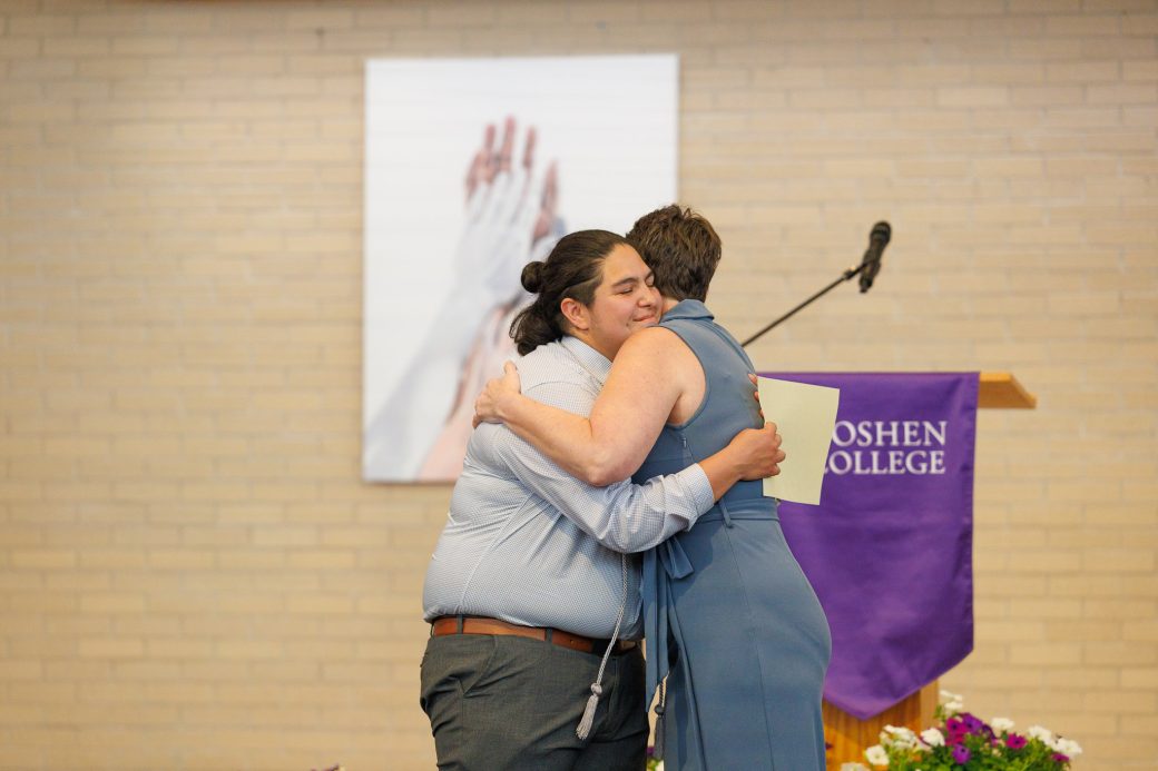 Jewel Yoder giving hug to student volunteer award winner