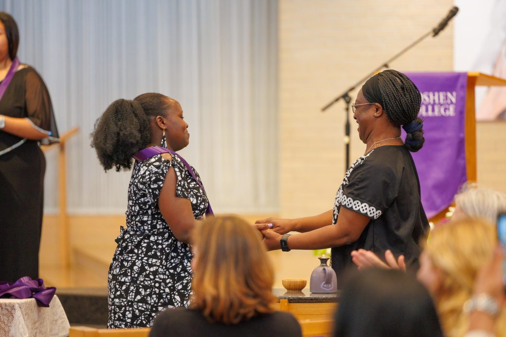 Nurse graduate receiving handshake by faculty