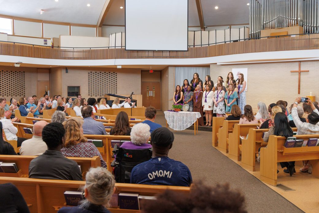 Group of 2026 nursing graduates standing before family and friends