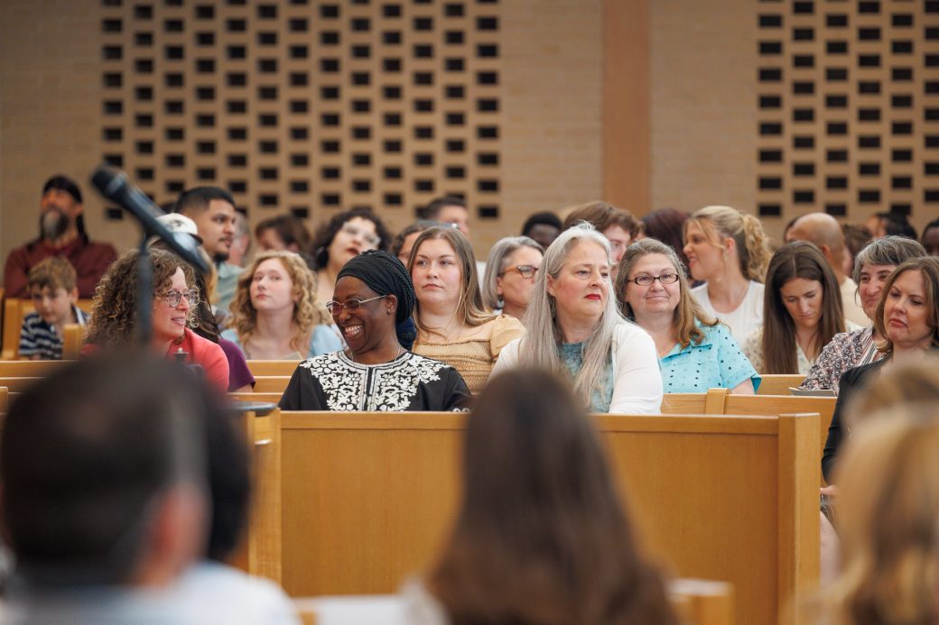 Faculty and staff laughing in the audience