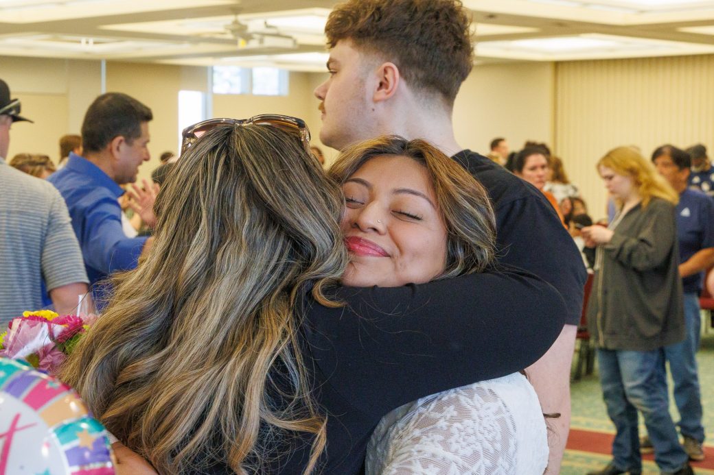 Nursing graduate close up hugging a friend
