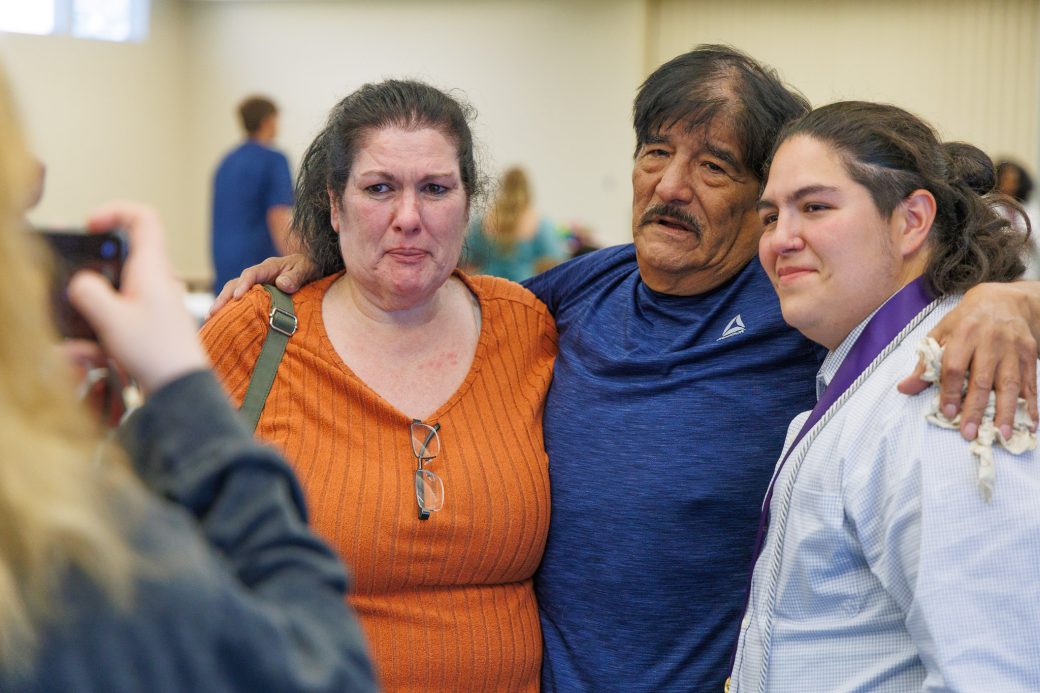 Nursing graduate posing with parents for photo