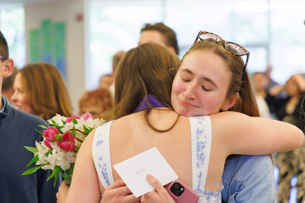 Nursing graduate hugging friend