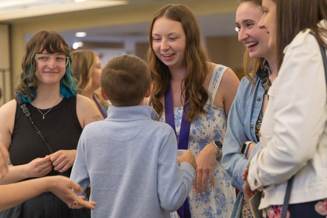 Nursing graduate talking to young person