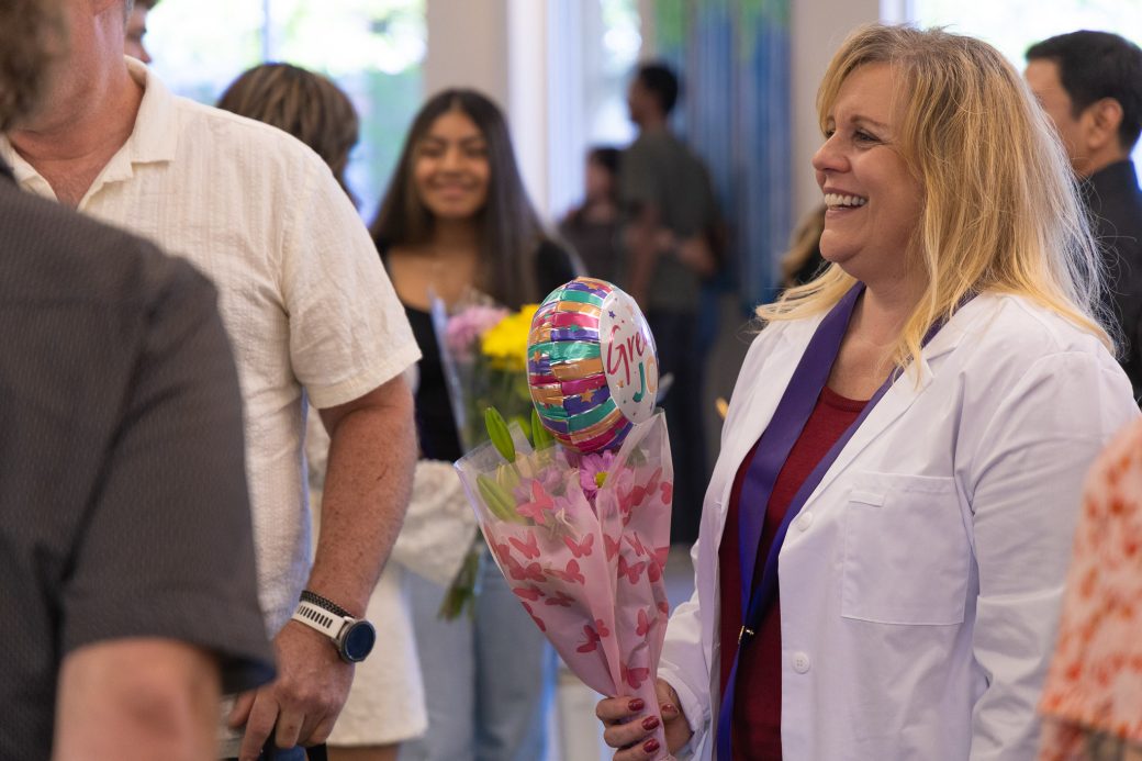 MSN student smiling holding flowers